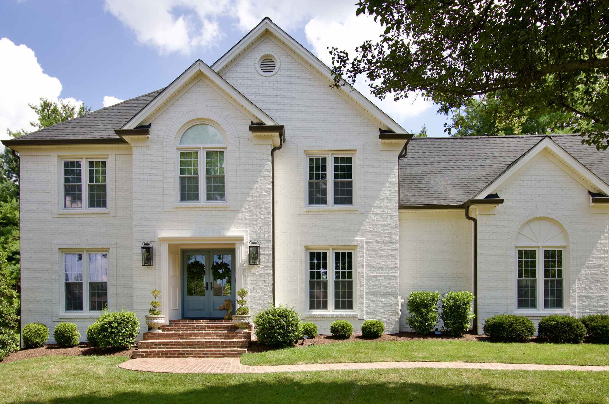 Colonial-style brick home with symmetrical windows and arched entry remodeled by Trade Works Remodeling in Louisville, Kentucky