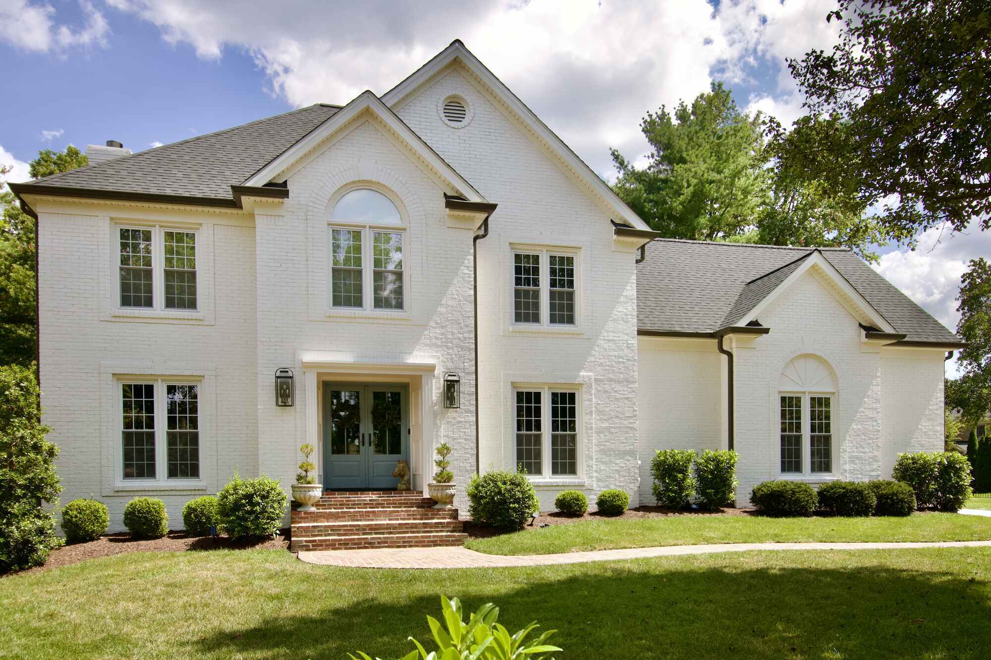 Wide front view of remodeled white brick custom home by Trade Works Remodeling in Louisville, KY
