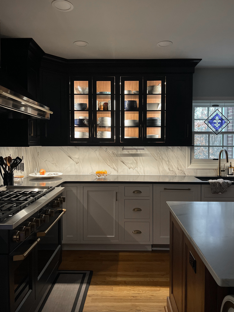 Illuminated upper cabinets with marble backsplash in luxury kitchen renovation in Prospect, KY