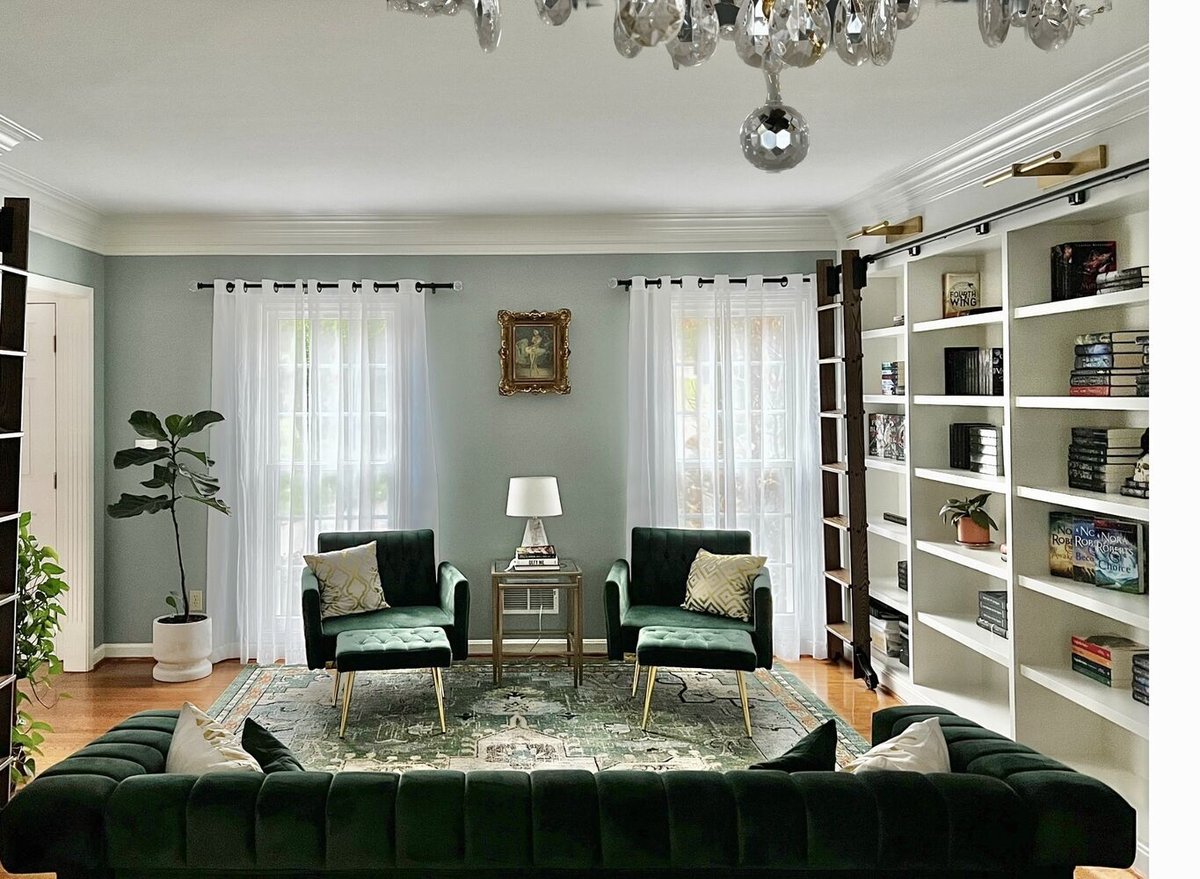 Stylish custom home library with green velvet seating and wall-to-wall bookshelves in Anchorage, KY