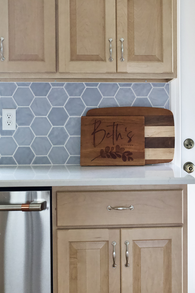 Personalized cutting board on quartz countertop in a kitchen remodel by Trade Works Remodeling in Anchorage, KY