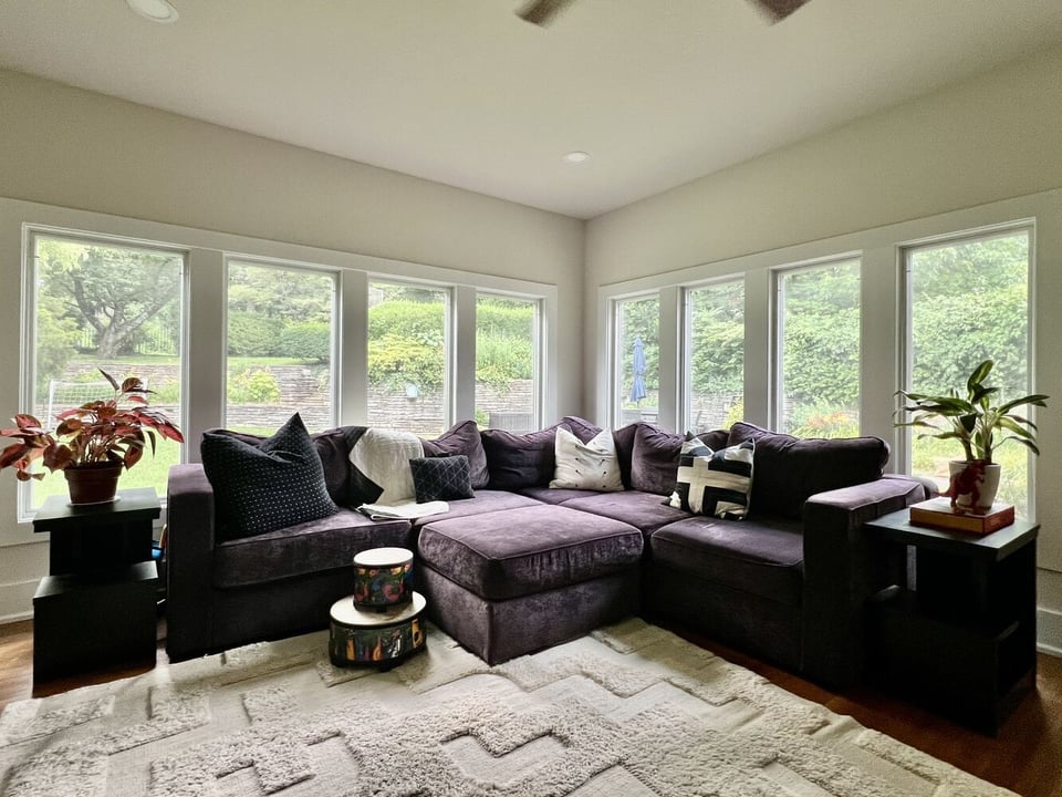 Bright sunroom with large windows and sectional seating by Trade Works Remodeling in Prospect, KY