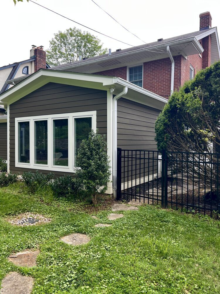 Side exterior of custom home addition with landscaped path in Louisville by Trade Works Remodeling