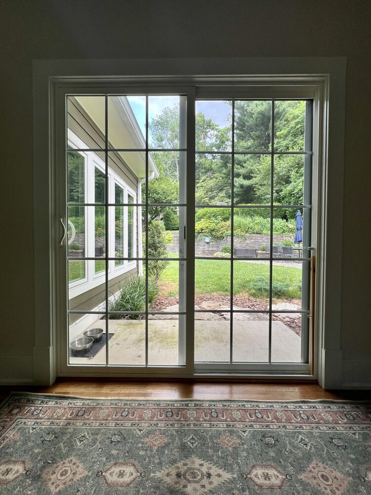 View through glass sliding doors to lush backyard in custom home by Trade Works Remodeling, Louisville, KY