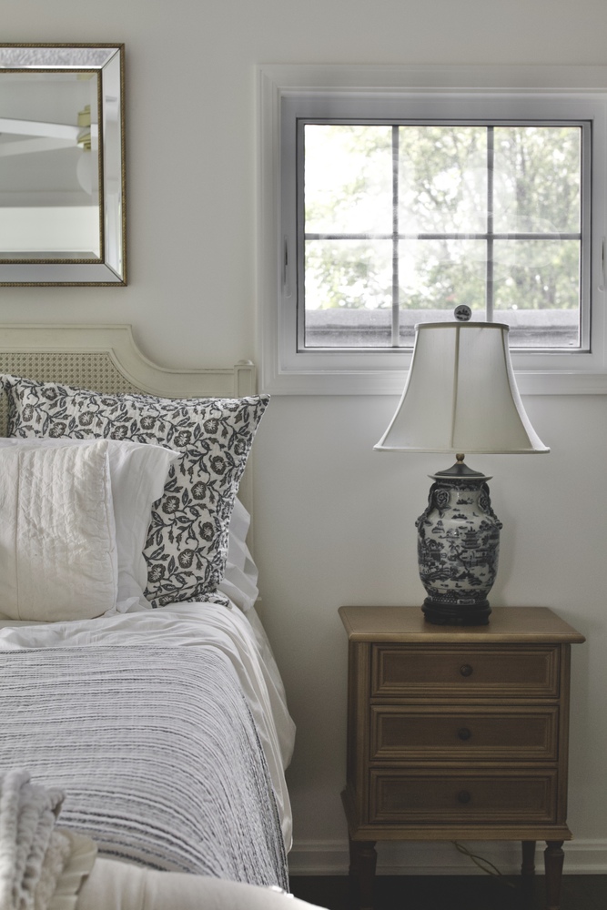 Bedroom remodel with patterned pillows and nightstand lamp by Trade Works Remodeling in Louisville, KY