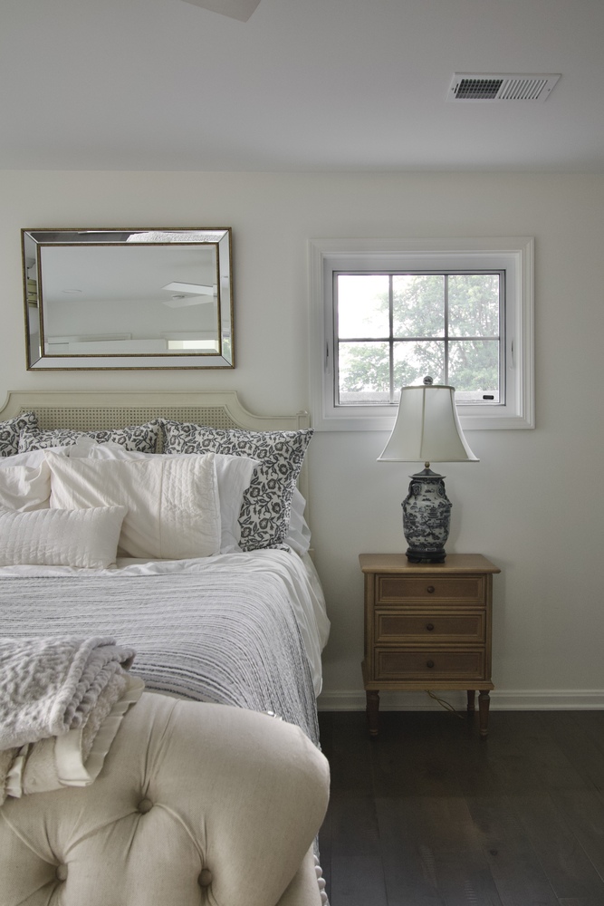 Bedroom remodel with upholstered bed, nightstand, and window by Trade Works Remodeling in Louisville, KY