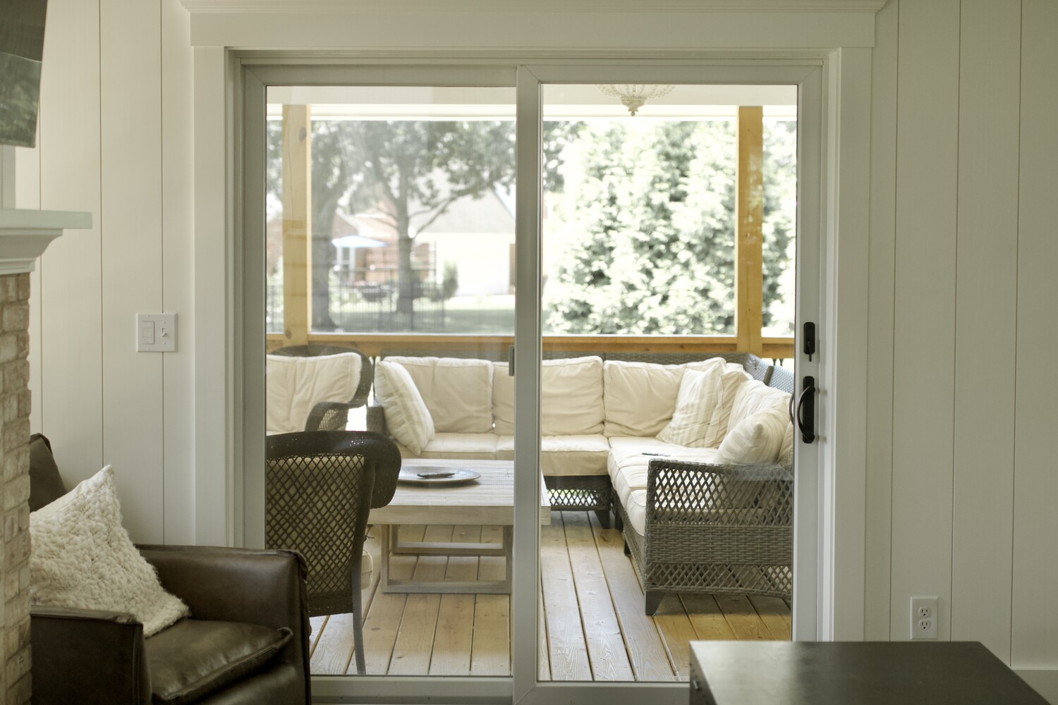 Comfortable patio lounge visible through glass doors in a Louisville custom home by Trade Works Remodeling