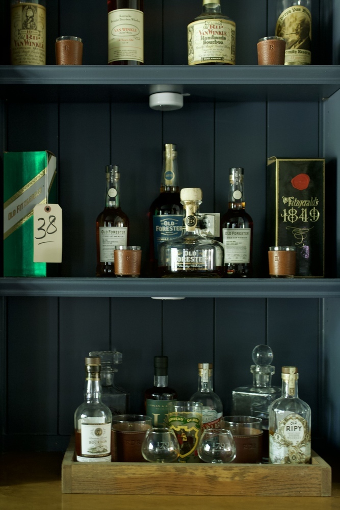 Curated bourbon shelf with high-end labels in a custom bar by Trade Works Remodeling in Louisville, KY