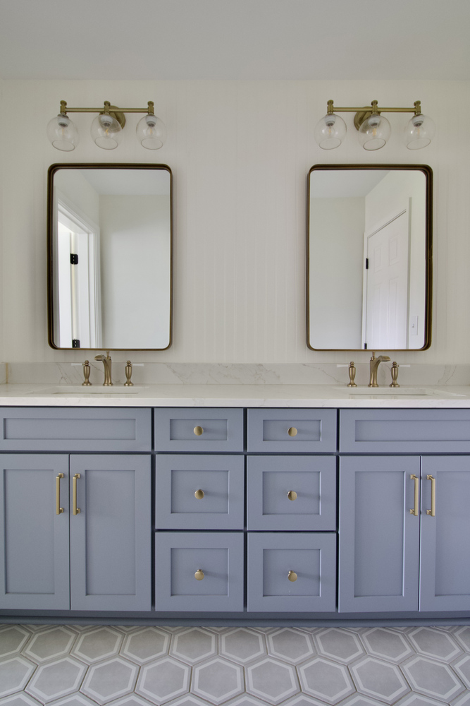 Double vanity with blue cabinetry and marble counters by Trade Works Remodeling in Owl Creek, KY
