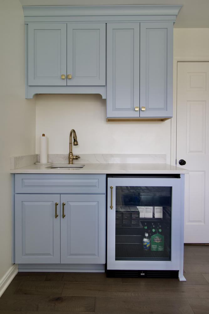 Kitchenette with blue cabinets and beverage fridge by Trade Works Remodeling in Old Brownsboro Place, KY