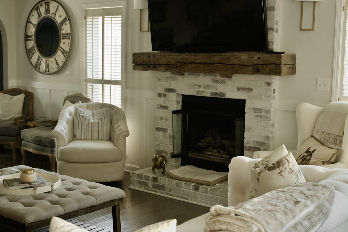 Living room remodel with white chairs and brick fireplace by Trade Works Remodeling in Louisville, KY