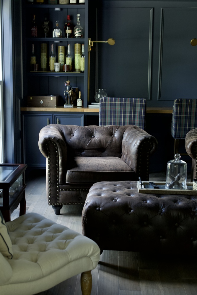 Luxurious leather seating and plaid bar stools in a Trade Works Remodeling bourbon room in Louisville, Kentucky