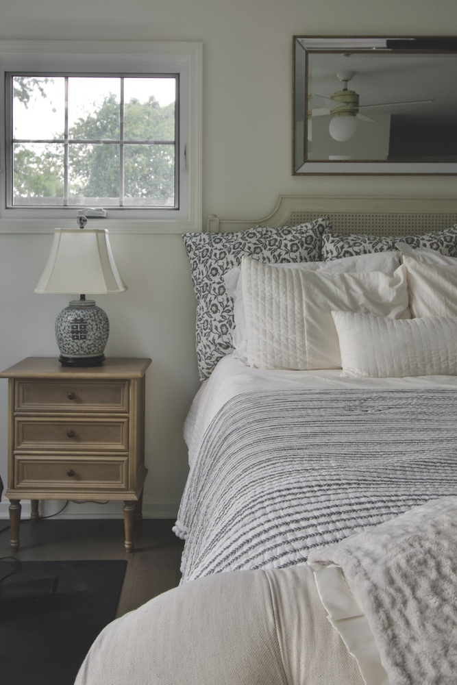 Master bedroom remodel with patterned pillows and wood nightstand by Trade Works Remodeling in Owl Creek, KY