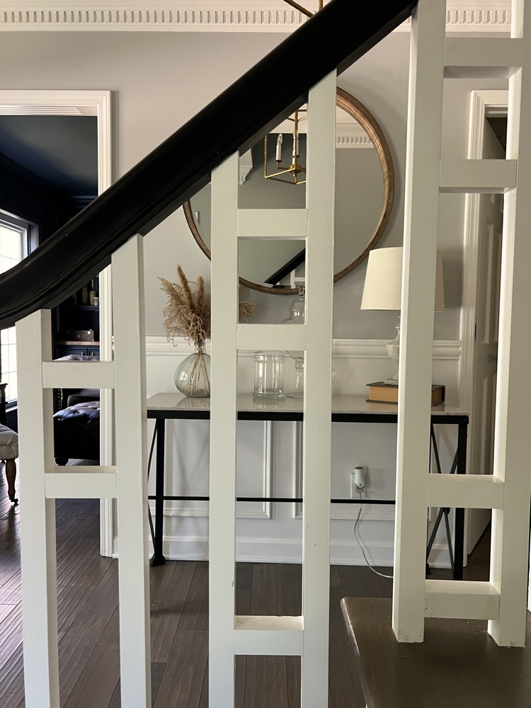 Modern staircase with white railing and decorative entry console by Trade Works Remodeling in Louisville, KY