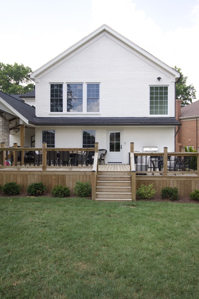 Rear view of white painted brick custom home with wood deck by Trade Works Remodeling in Louisville, KY