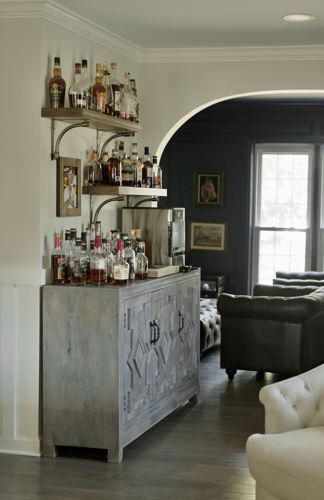 Stylish home bar with liquor cabinet and arched entry by Trade Works Remodeling in Prospect, KY