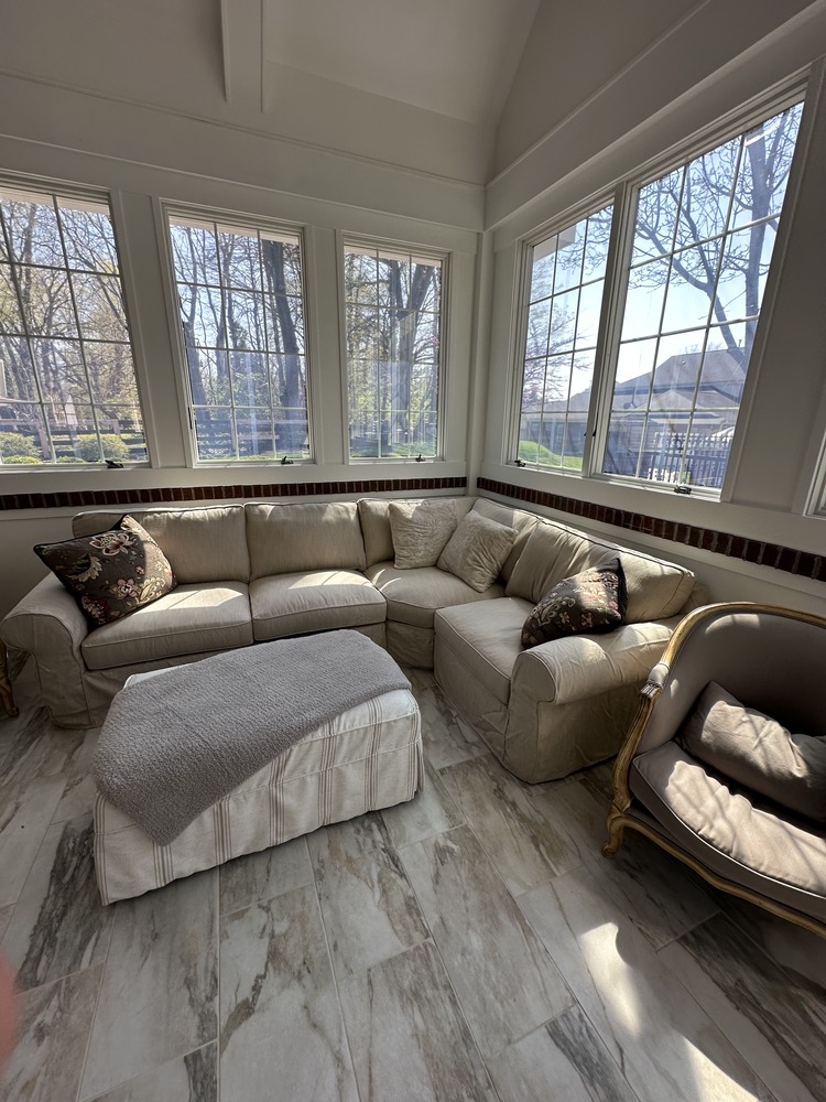 Bright custom sunroom with sectional seating by Trade Works Remodeling in Louisville, KY