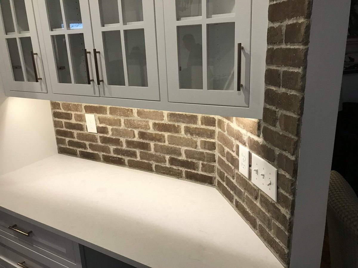 Kitchen design featuring white cabinets and brick detail by Trade Works Remodeling in St. Matthews, KY