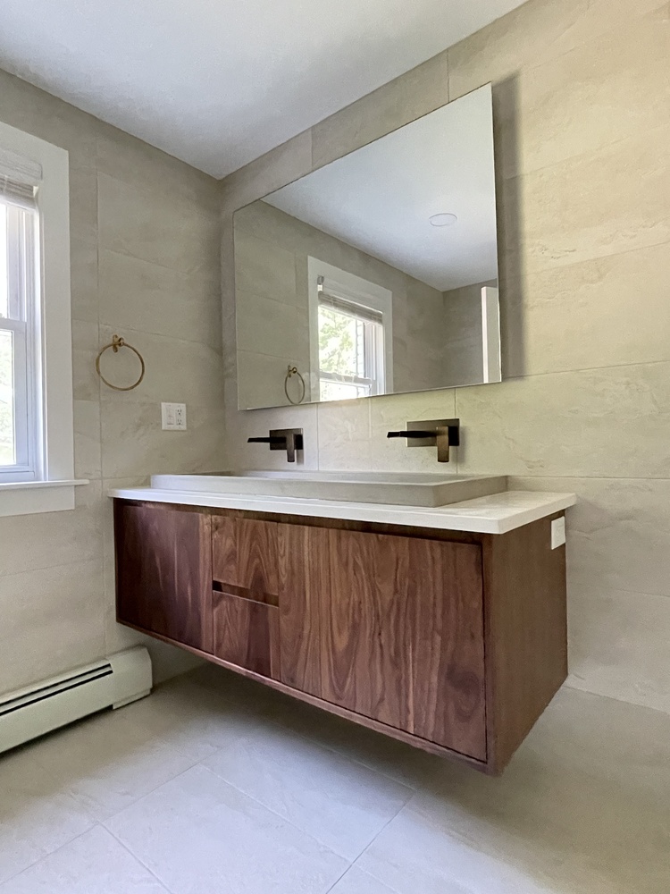 Natural light bathroom shot showing wood vanity and mirror by Trade Works Remodeling in Louisville, KY