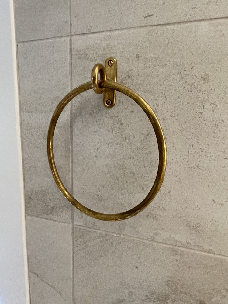 Stylish brass towel ring installed on tile wall in Louisville, KY bathroom by Trade Works Remodeling