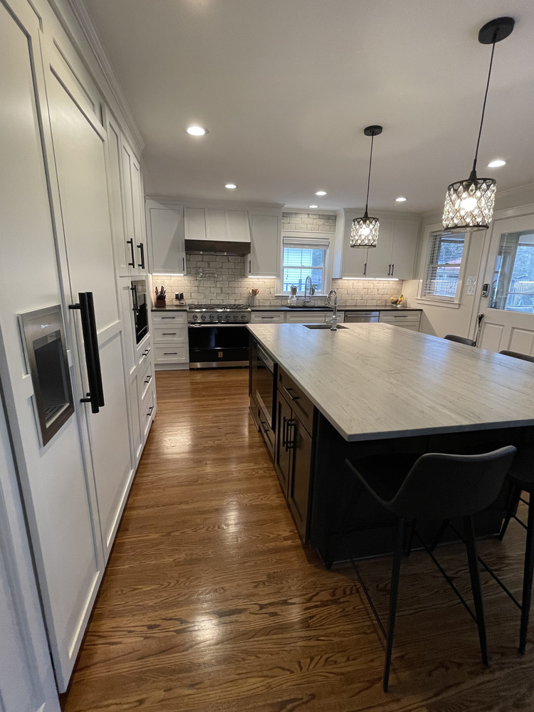 Wide view of Louisville custom kitchen by Trade Works Remodeling with dark island and wood flooring