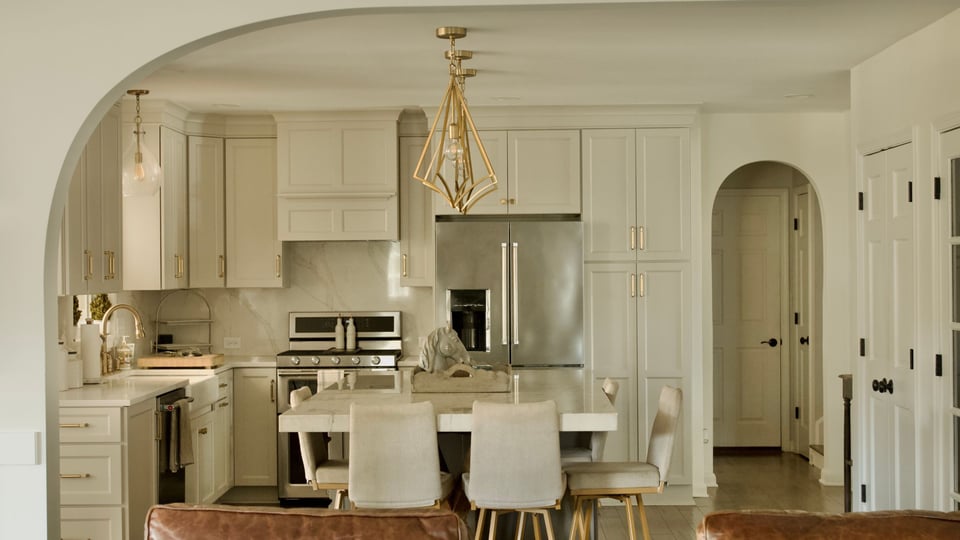 Louisville kitchen remodel with gold accents and neutral cabinets with barstool seating at kitchen island