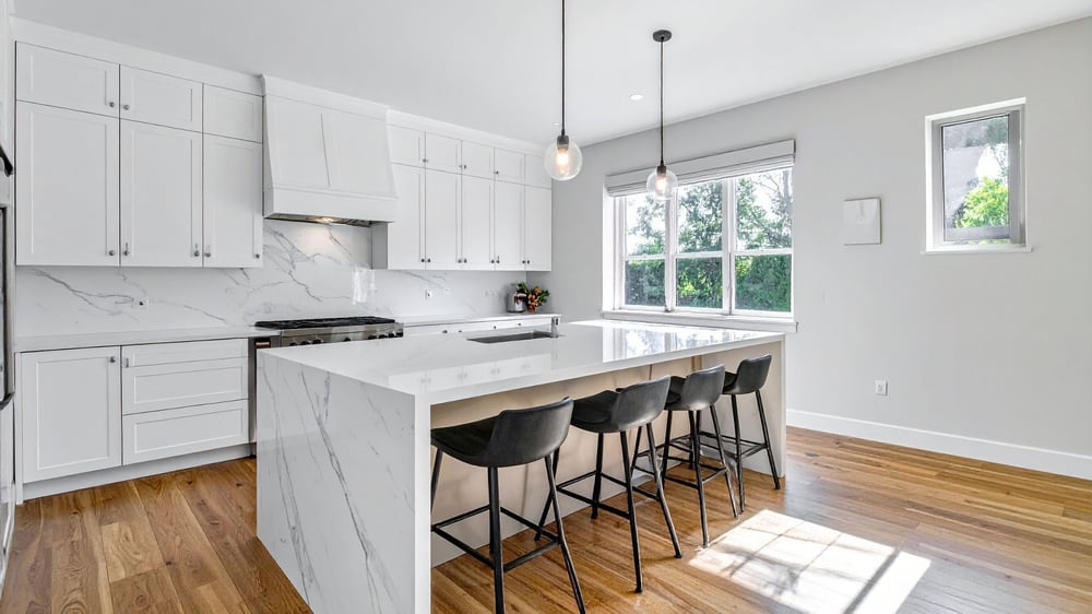 contemporary kitchen with waterfall edge kitchen island and white cabinets