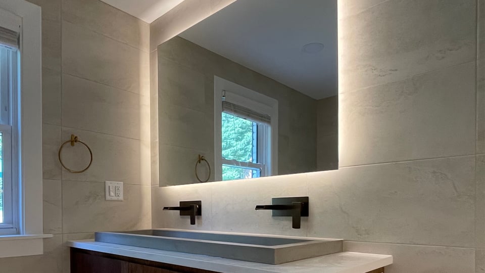 modern bathroom with back-mirror lighting and a double sink