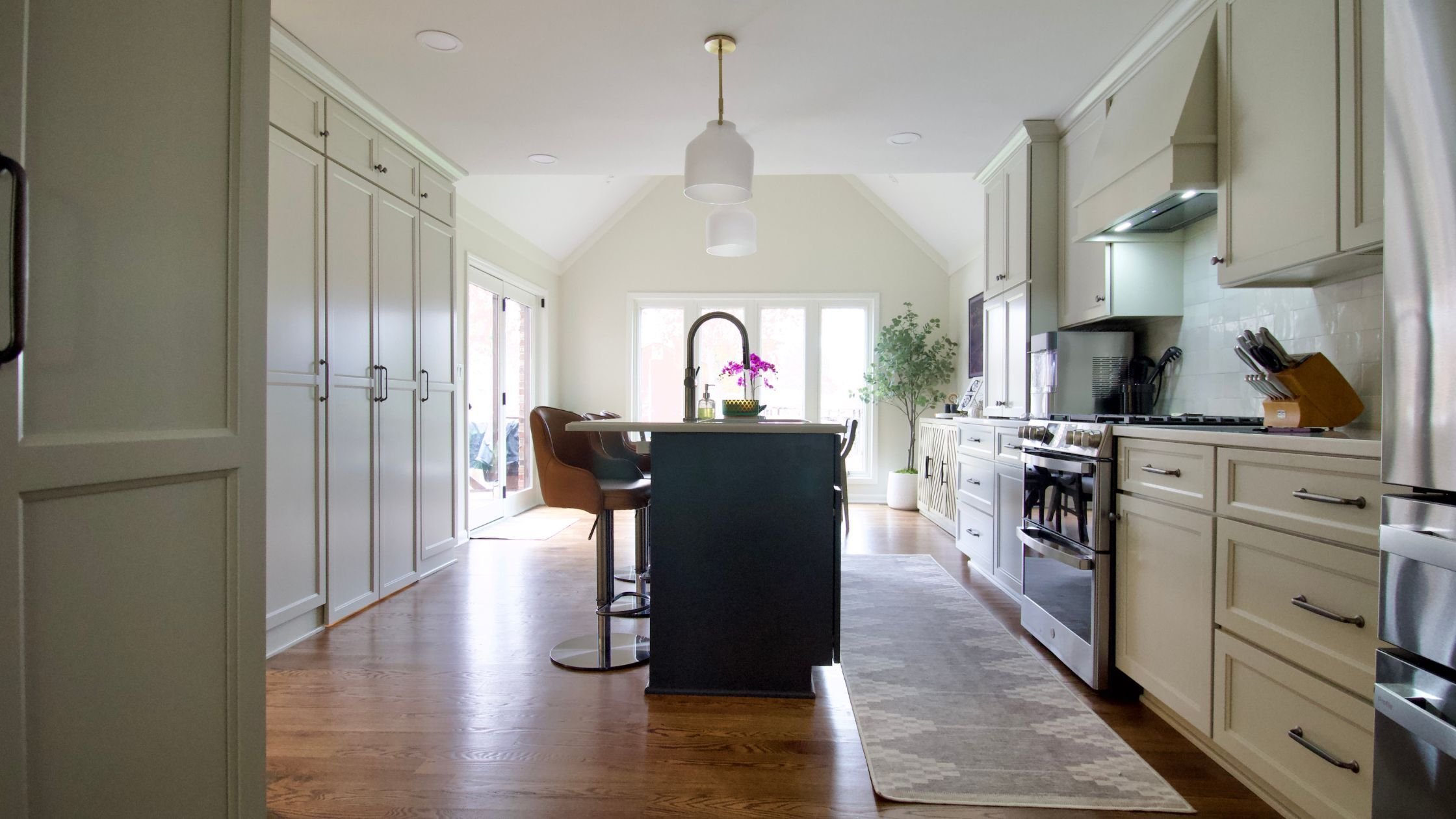modern kitchen renovation in louisville with statement blue island and white cabinet storage