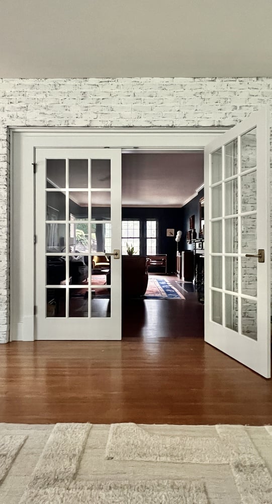 Living room transition with glass double doors in remodeled Highlands, KY home by Trade Works Remodeling
