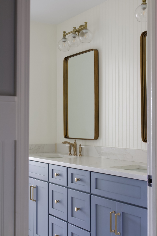 Double vanity with blue cabinetry and marble counters by Trade Works Remodeling in Prospect, KY