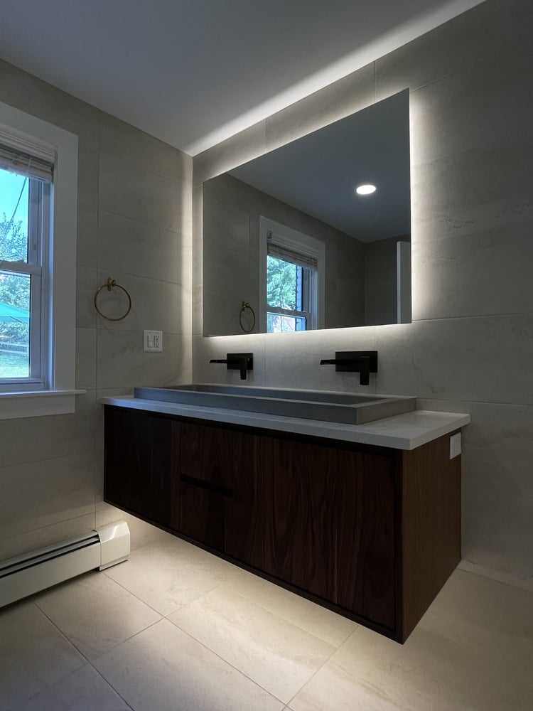 Custom bathroom remodel in Louisville, KY featuring wood vanity and soft wall lighting by Trade Works Remodeling