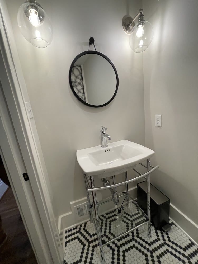 Small bathroom remodel with pedestal sink and round mirror by Trade Works Remodeling in Louisville, KY